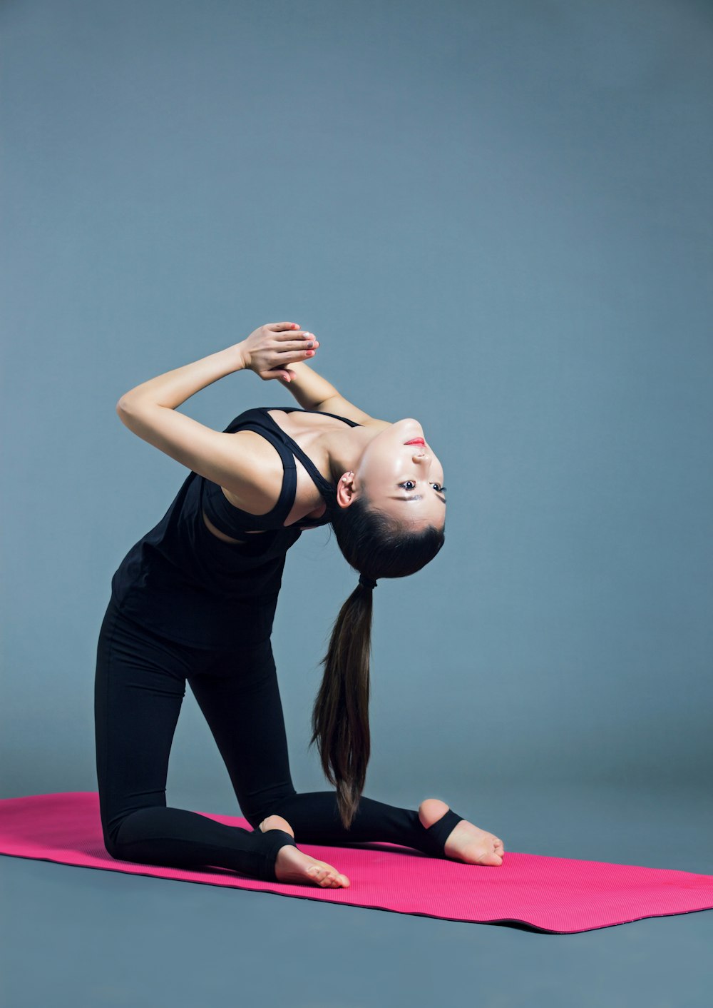 woman in black tank top and blue pants doing yoga