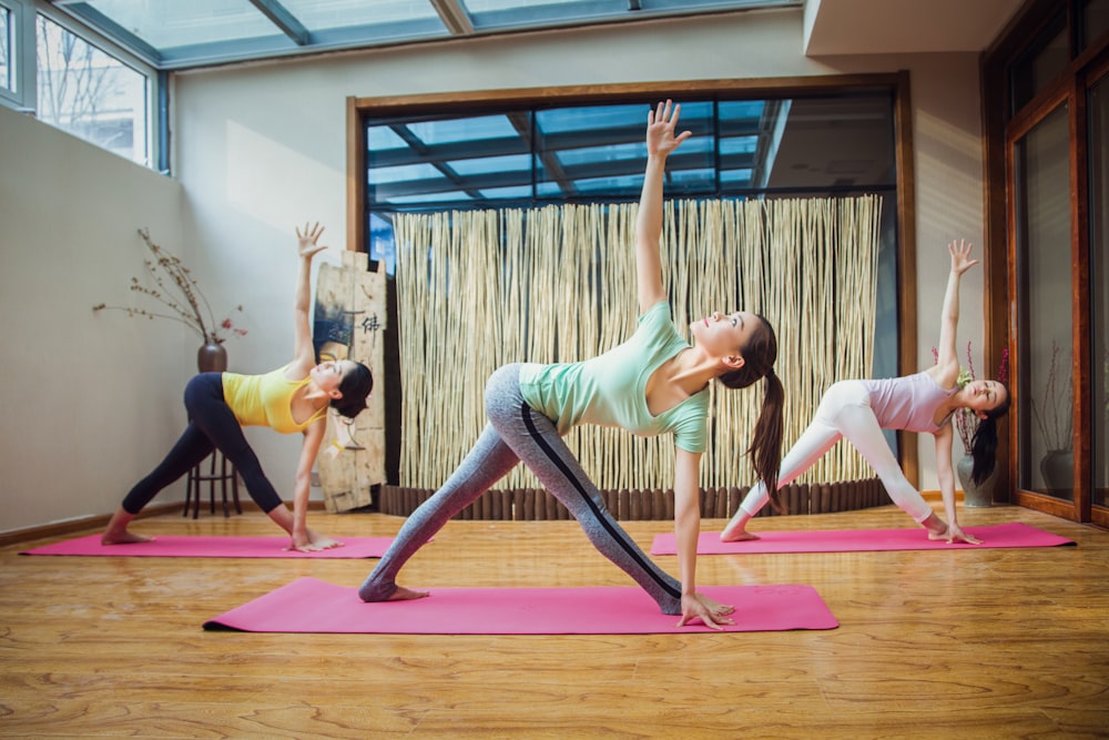 Frau in grauem Tanktop und grauen Leggings beim Yoga