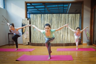 2 women in pink tank top and pink leggings doing yoga