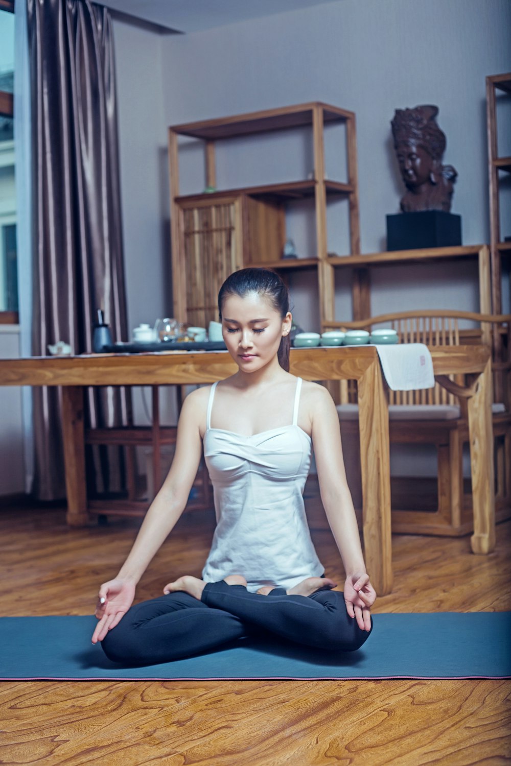 woman in white tank top sitting on brown wooden chair