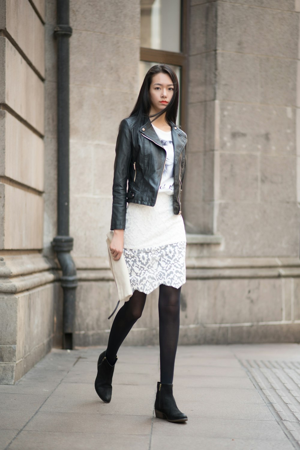 a woman in a white dress and a black leather jacket