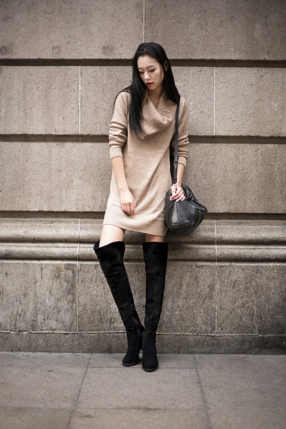 woman in beige long sleeve shirt and black pants standing on concrete stairs