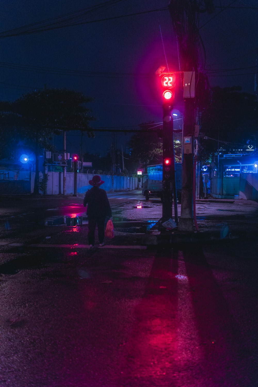 夜間に歩道を歩く黒いジャケットの男