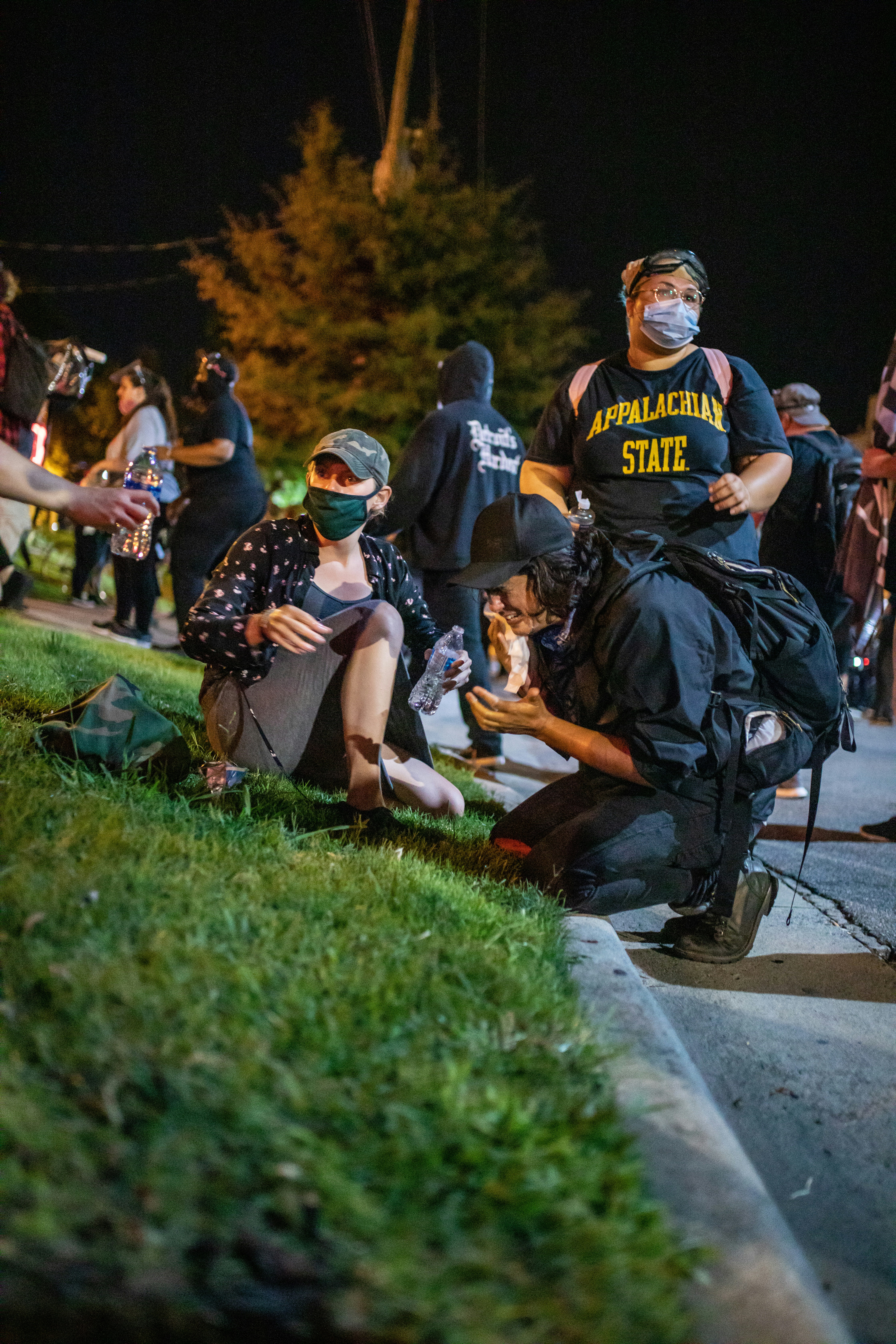 man in black and yellow crew neck t-shirt sitting on gray concrete bench