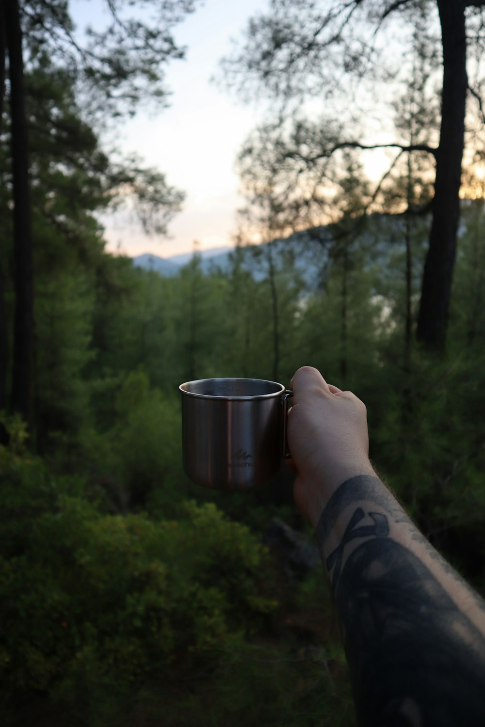 person holding stainless steel cup