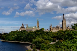 brown and white concrete building near green trees under blue sky during daytime