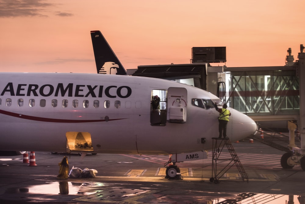 Avión de pasajeros blanco y azul en el aeropuerto durante el día