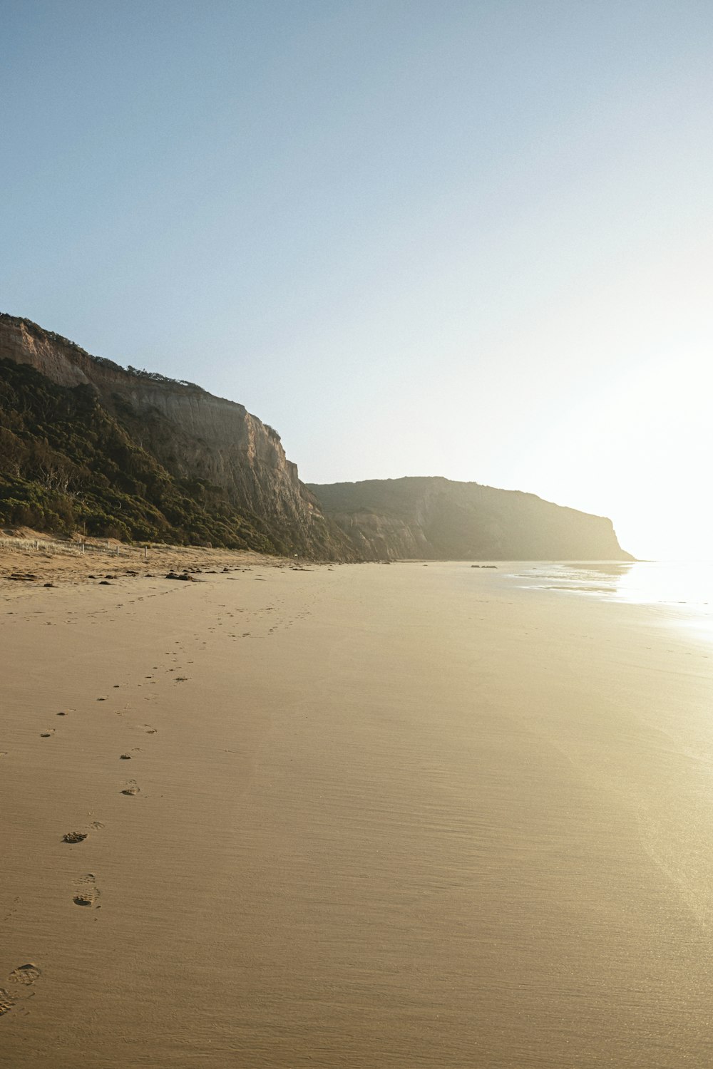 brown sand beach near brown mountain during daytime