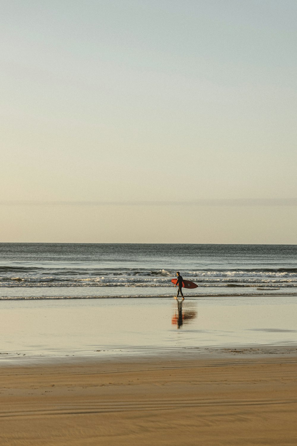 person in red shirt walking on beach during daytime