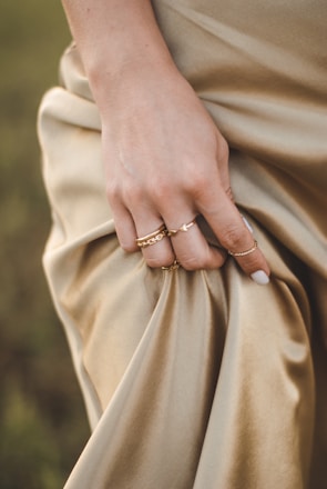 person wearing gold ring and gold ring