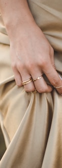 person wearing gold ring and gold ring