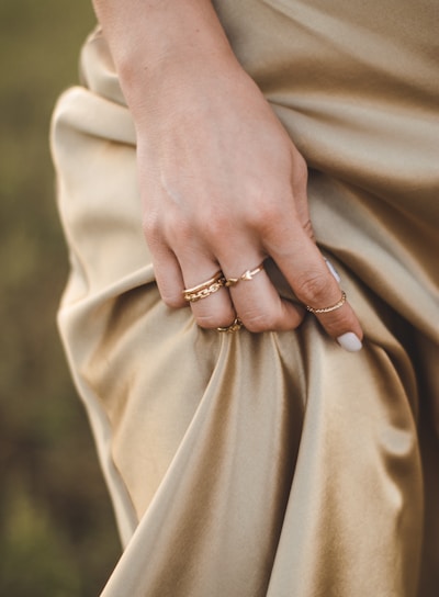 person wearing gold ring and gold ring