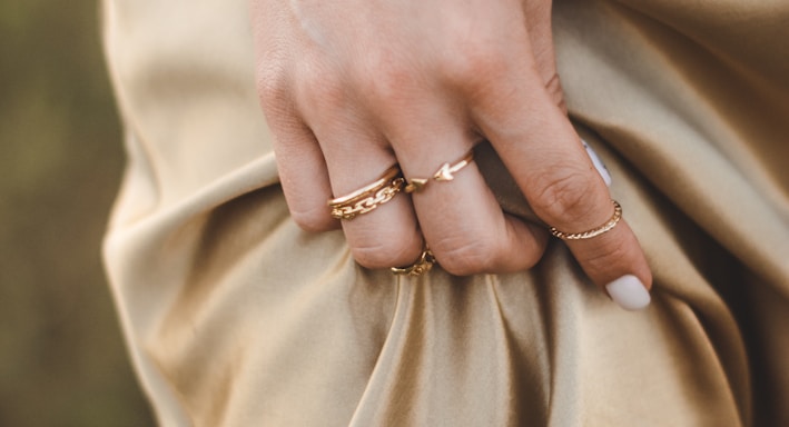 person wearing gold ring and gold ring