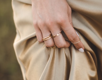 person wearing gold ring and gold ring