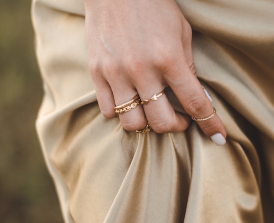 person wearing gold ring and gold ring