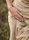 Close-up of a woman's hand adorned with éclat d'or rings, resting on a champagne gold fabric.