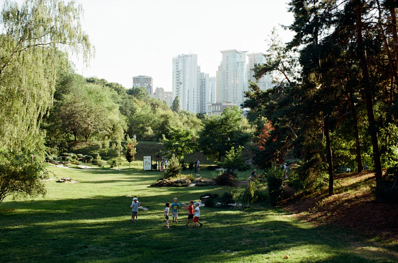 People on a green grass field near high-rise buildings