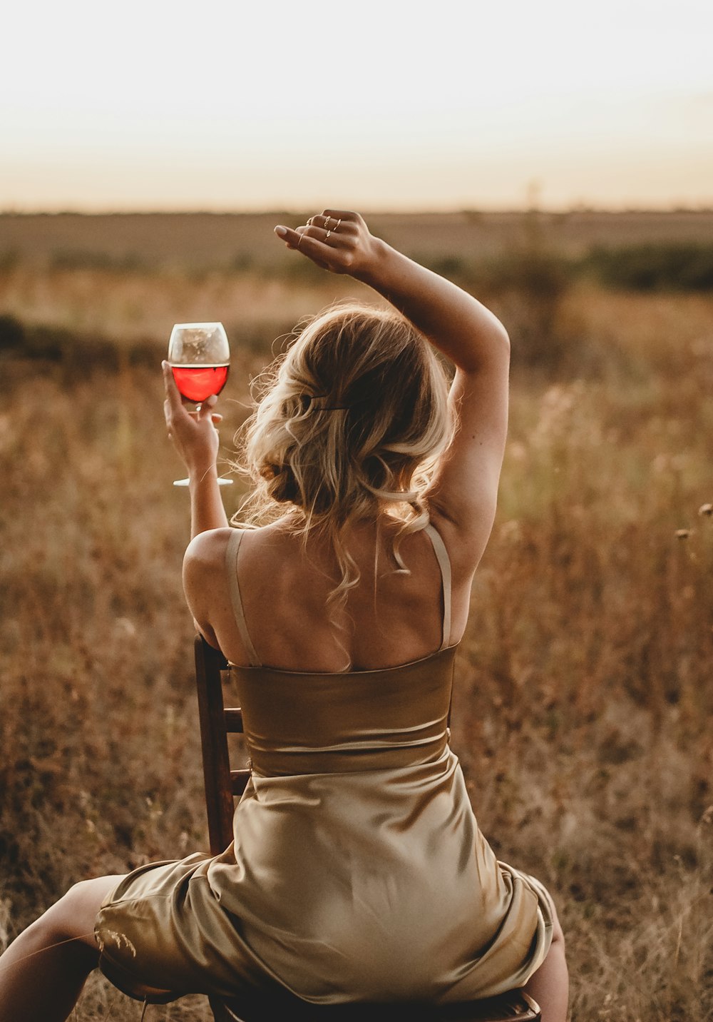 woman in brown spaghetti strap top holding red and white ceramic mug