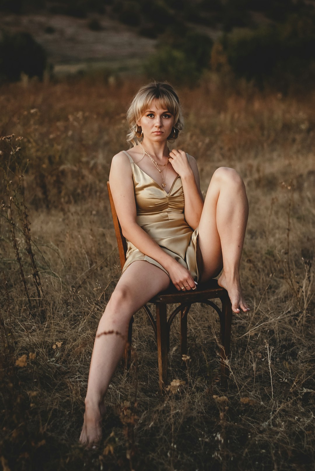 woman in brown sleeveless dress sitting on black chair