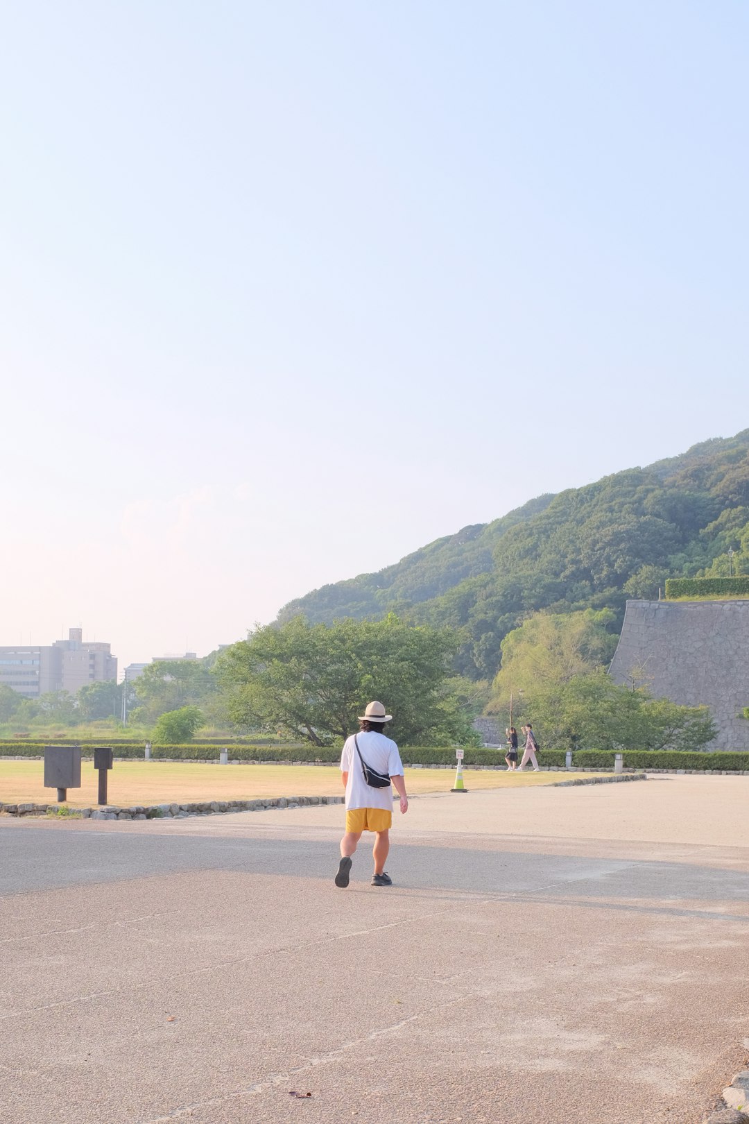 woman in white shirt and white shorts standing on brown sand during daytime