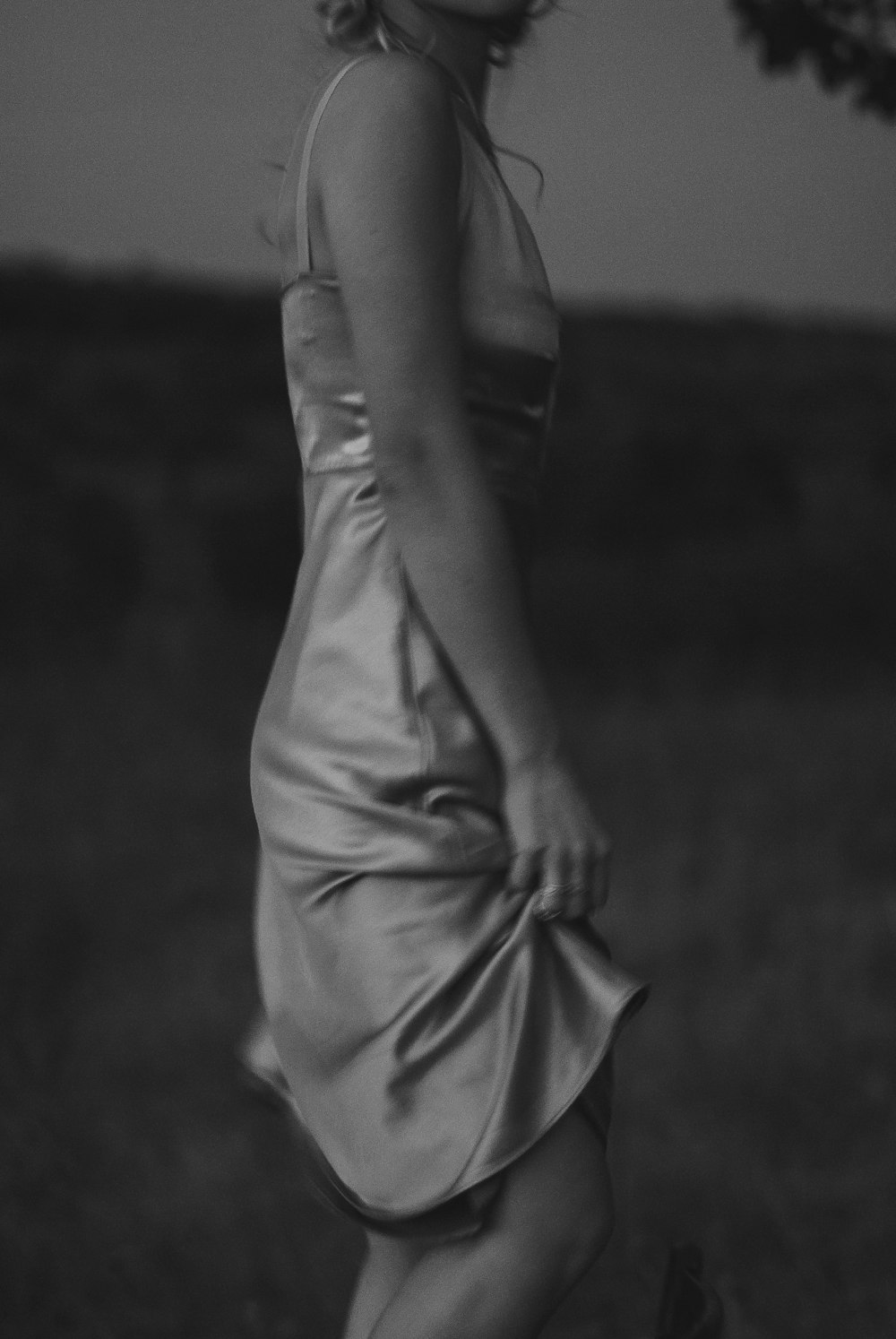 a black and white photo of a woman in a dress