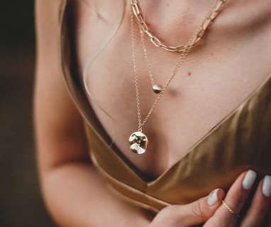 woman in gold sleeveless dress wearing gold necklace