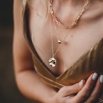 woman in gold sleeveless dress wearing gold necklace