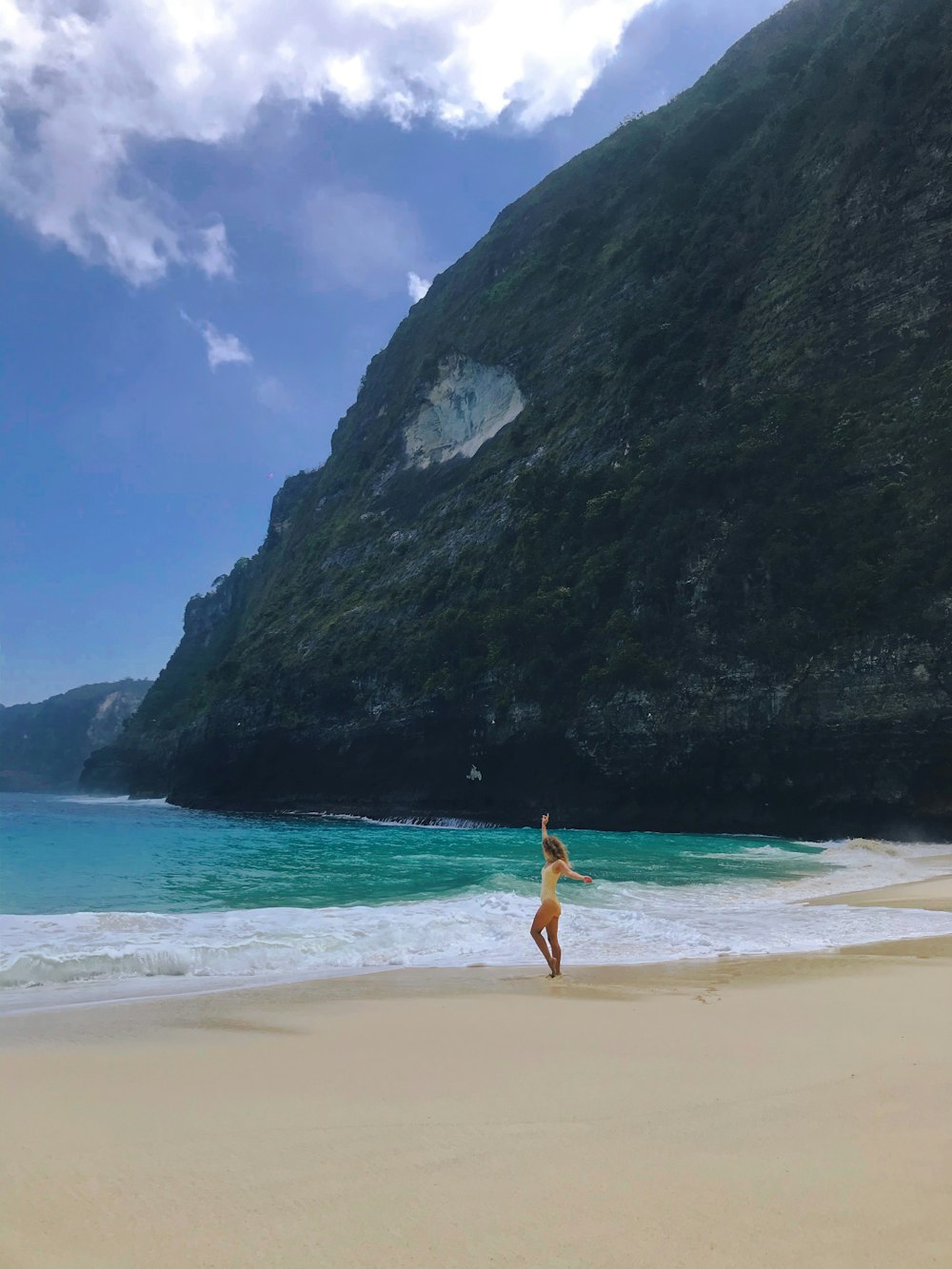 Mujer en bikini rojo caminando por la playa durante el día