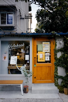 A cheerful shop owner handing out flyers to interested customers outside their storefront.