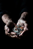 Close-up image of a veteran's hands holding a worn paratrooper badge