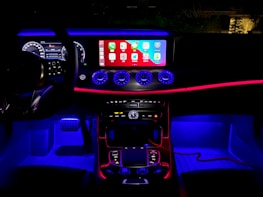 Elegant dashboard of a premium car illuminated with ambient lighting.