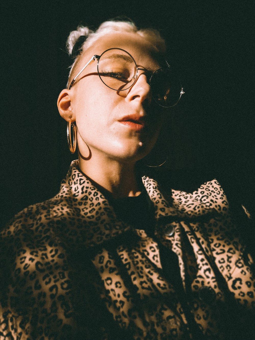 woman in black and white leopard print coat wearing black framed eyeglasses