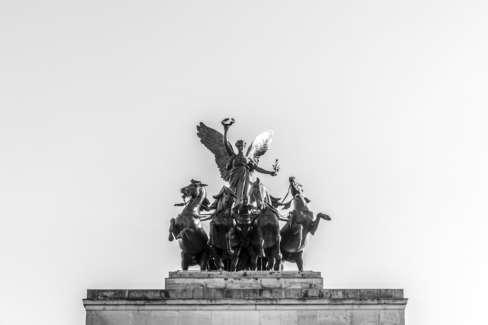 estatua de hormigón gris de un hombre montando a caballo