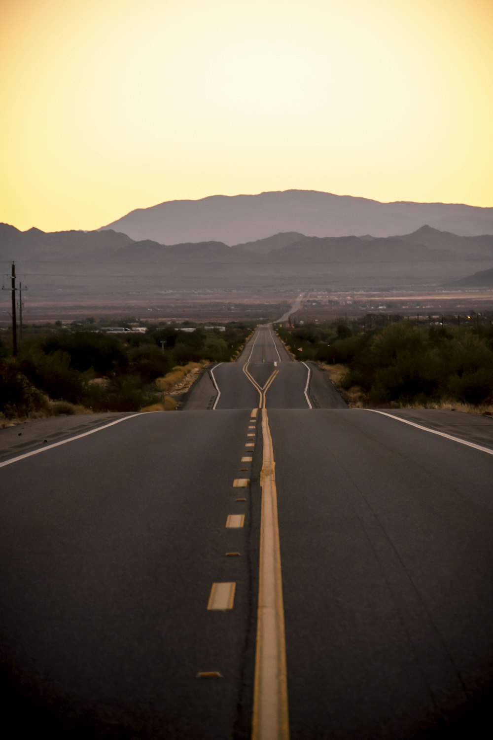 gray concrete road near green grass field during daytime