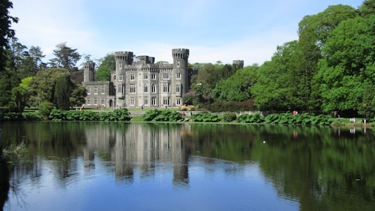 gray concrete building near green trees and river during daytime in Wexford Ireland