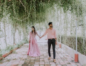 woman in pink dress standing beside man in black pants