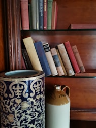 An elegant collection of old books and porcelain on a wooden table.