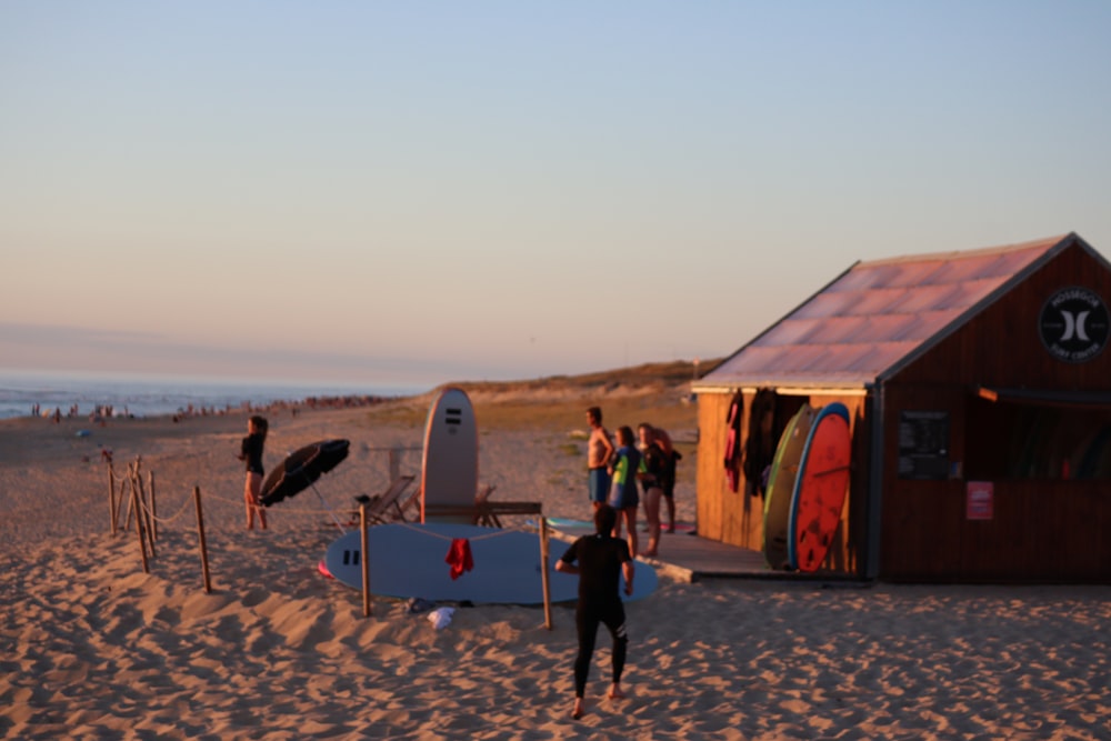 people standing near blue and brown wooden shed during daytime