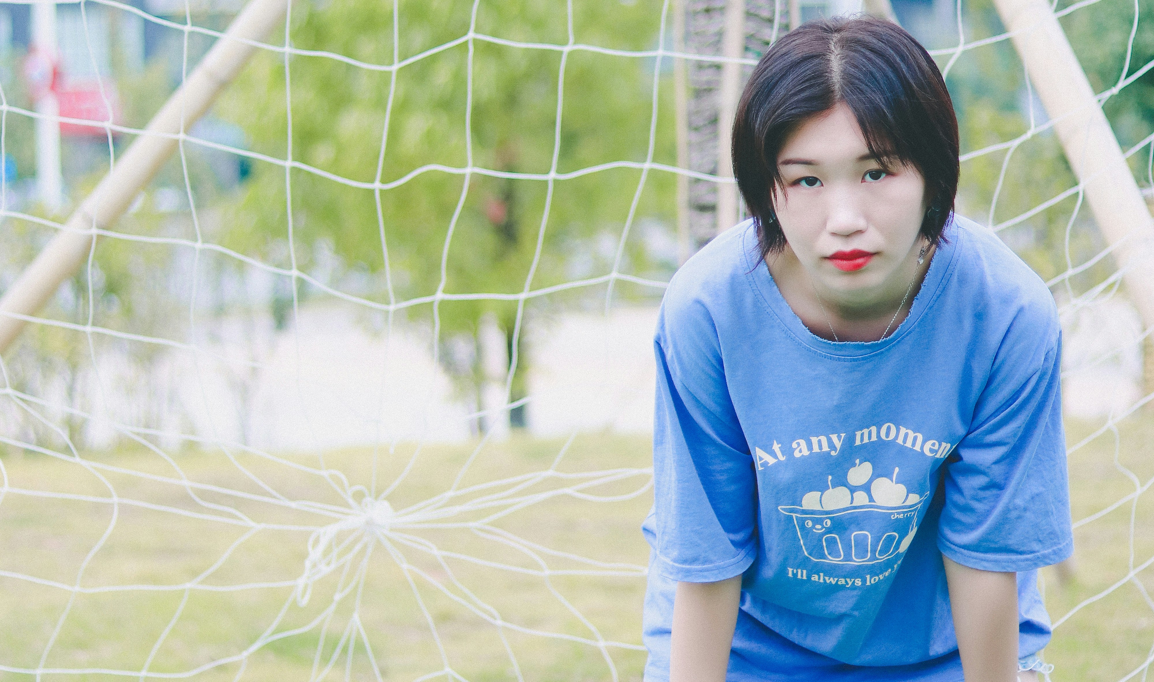 girl in blue crew neck t-shirt standing on green grass field during daytime