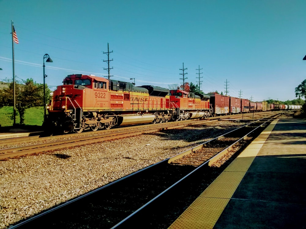 red train on rail tracks during daytime