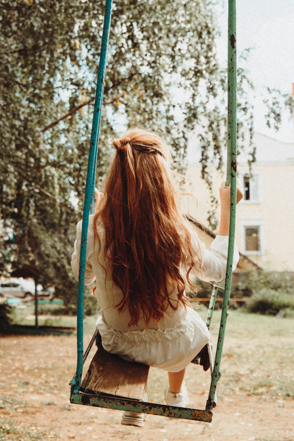 woman in white long sleeve shirt sitting on swing chair