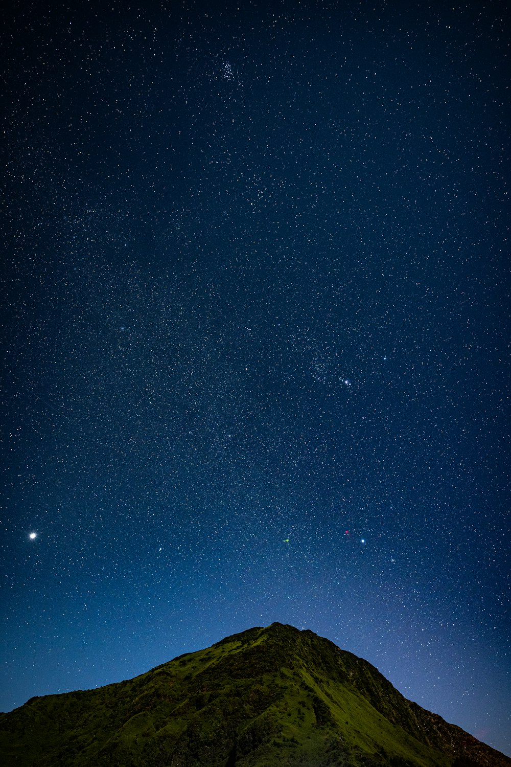 silhouette of mountain under blue sky during night time