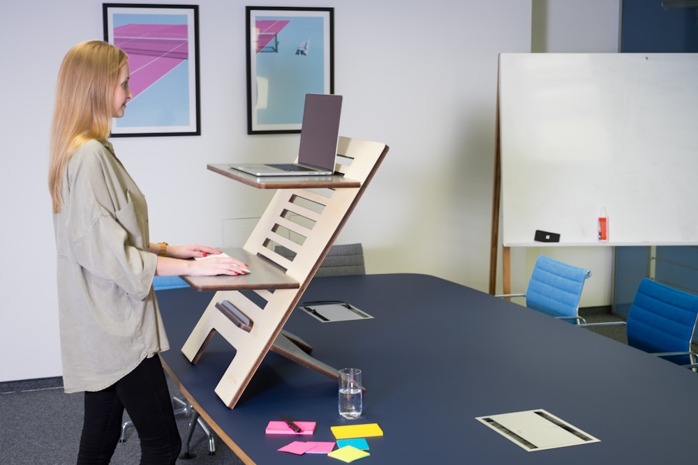 man in white dress shirt standing near black table