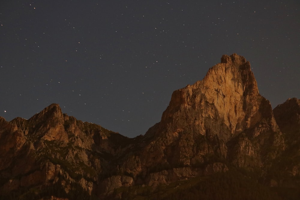 brown rocky mountain under blue sky during night time