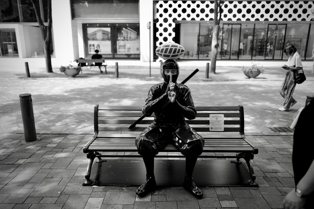 man sitting on bench holding smartphone