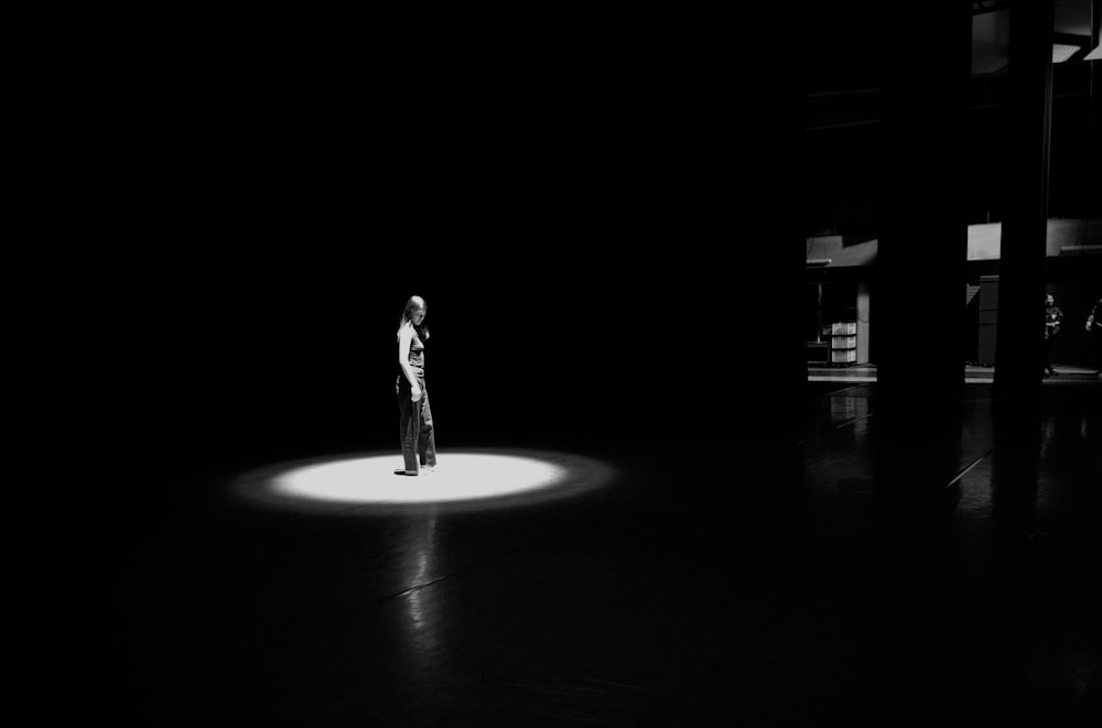 man in black jacket standing on black floor