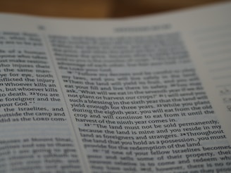 A close-up view of a page from a book featuring text written in English. The text is printed in a standard font with paragraph formatting. The page appears to have religious or formal content, as suggested by the textual arrangement and language used.