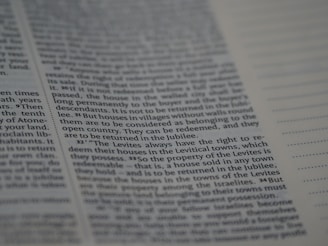 The image depicts a close-up of a page from a book, featuring text in a neat, justified layout. The text includes numbered sections and runs parallel to vertical dots on the right side.
