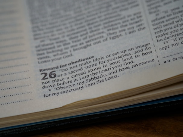 A close-up view of an open book displaying a page with text, focusing on a specific passage highlighted with larger numbers and a heading, 'Reward for Obedience'. The text is in a serif font on slightly yellowed paper, capturing a religious or scriptural context.
