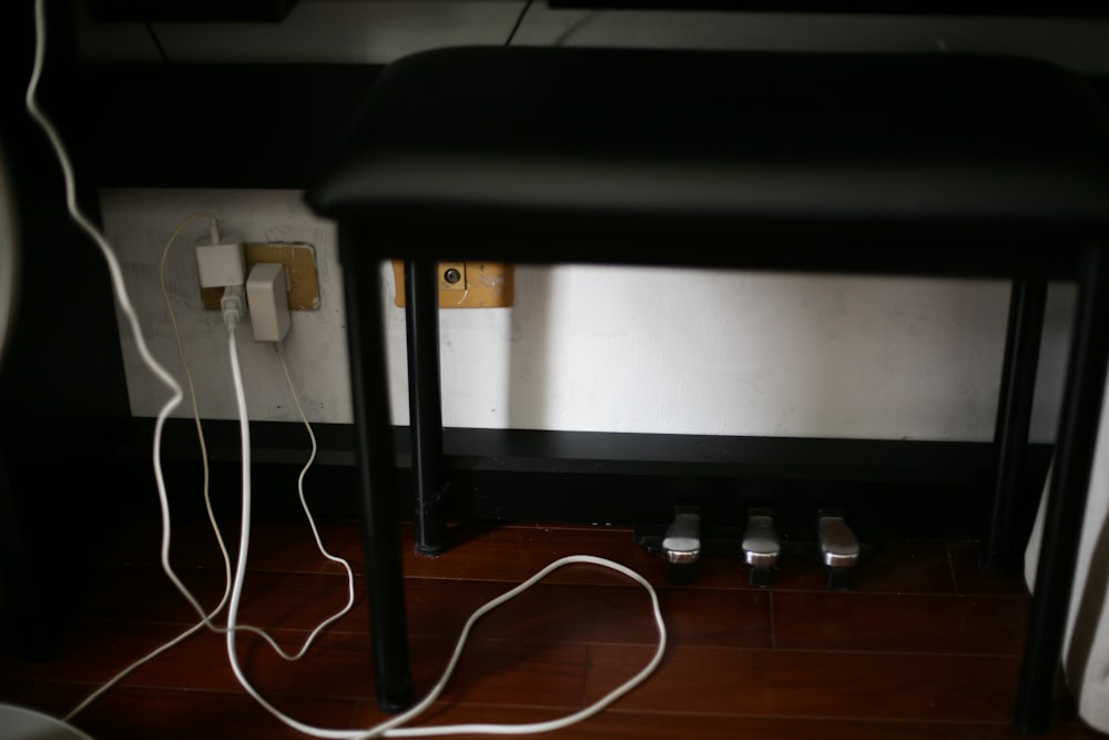 Cables eléctricos en blanco y negro sobre piso de madera marrón